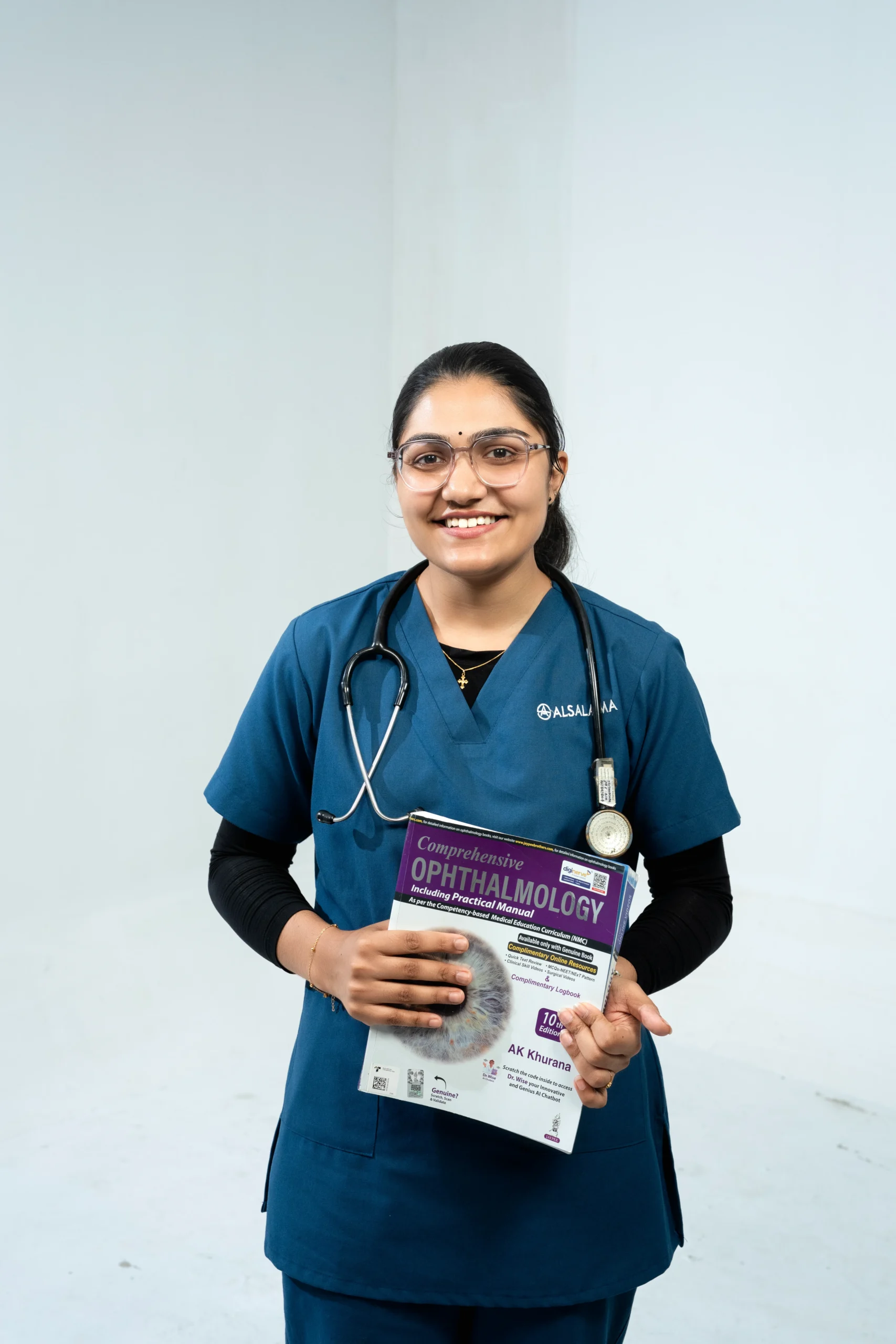 Al Salama healthcare student holding an ophthalmology textbook